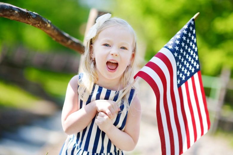 Adorable Little Girl Holding American Flag Outdoors On Beautiful Summer adorable-little-girl-holding-american-flag-outdoors-on-beautiful-summer