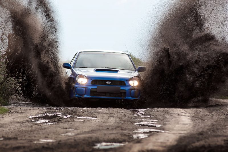 Subaru driving through dirt
