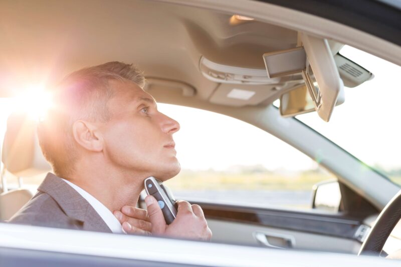 Man shaving in a car