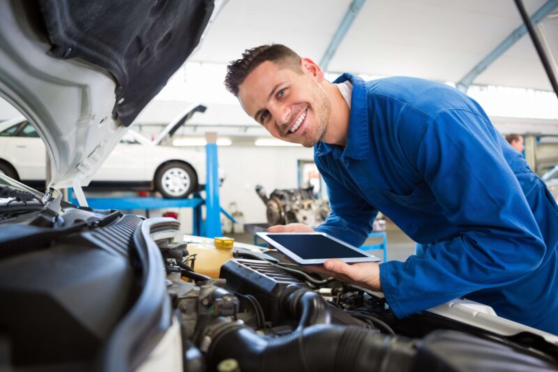 Mechanic checking under hood of car